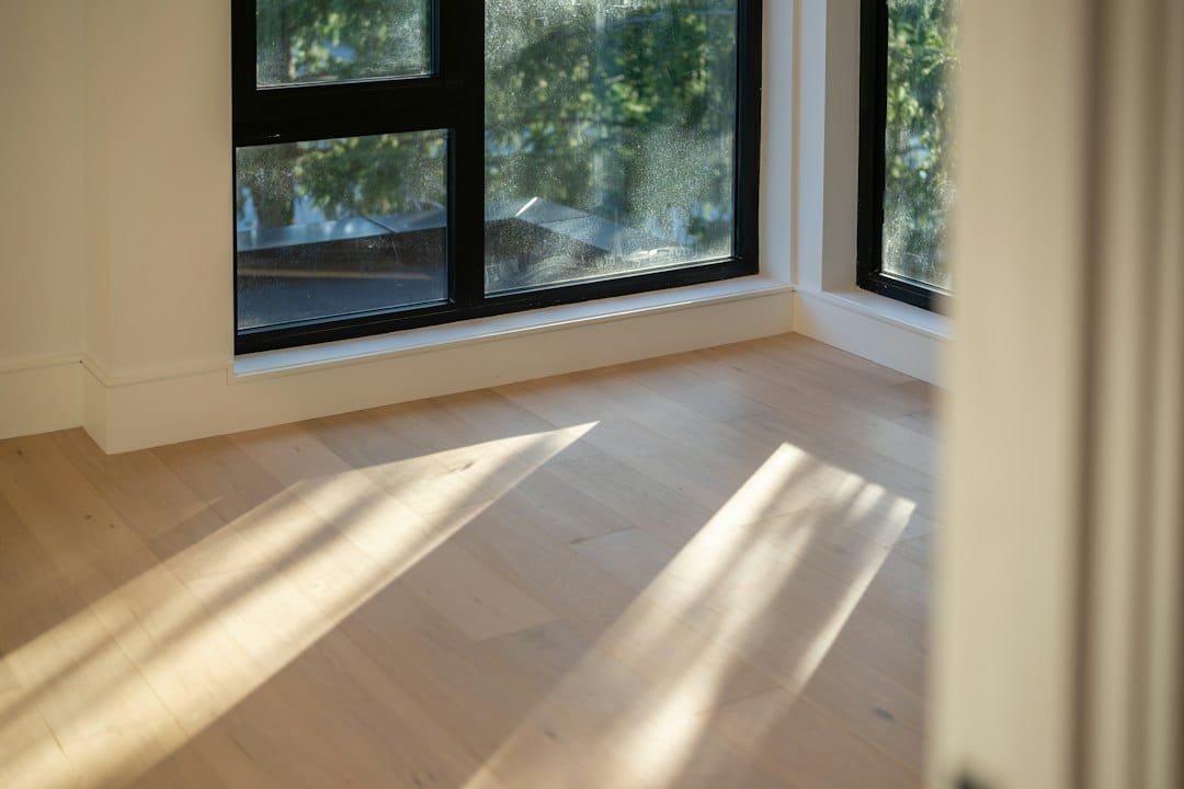 Sunlight across warm natural wide-plank hardwood flooring